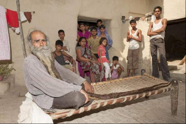 Guru Kailash Singh com amigos e familiares em sua casa.(Imagem:Richard Grange/Barcroft India/Getty Images)