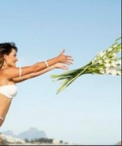 Laura Keller festeja 2014 com papel na TV e joga flores ao mar.(Imagem:Divulgação)