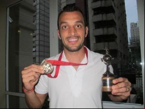 Edu Dracena mostra a medalha e a réplica da Taça Libertadores.(Imagem:Adilson Barros/Globoesporte.com))