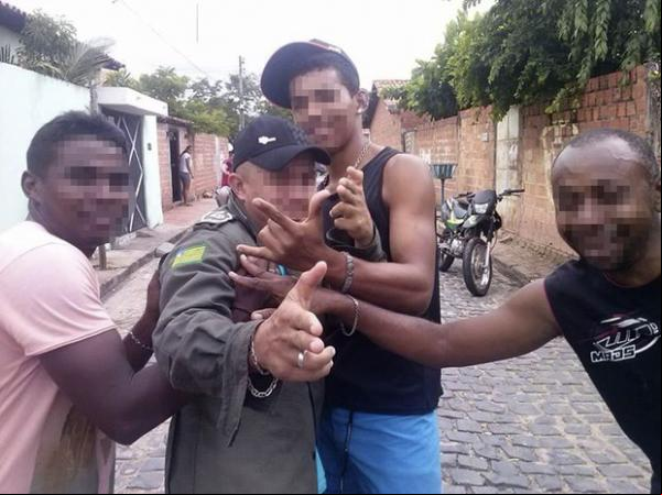 Fotografia mostra o mesmo homem fardado já simulando ter sido imobilizado.(Imagem:Reprodução/Facebook)