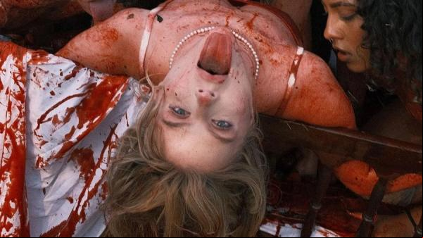 Em novo clipe, Luísa aparece em uma cama com manchas vermelhas fazendo alusão ao sangue e ao líquido que solta do morango.(Imagem:Divulgação)
