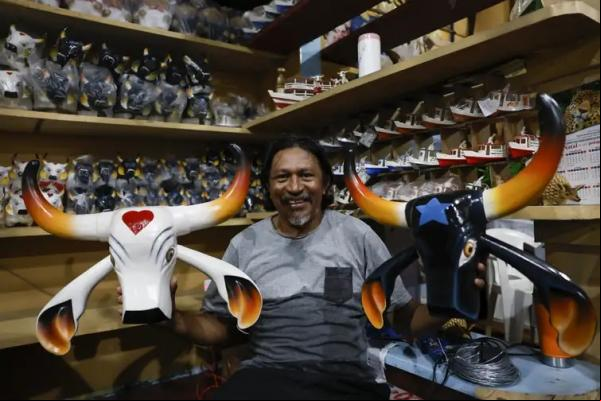 O artesão Mateus Pereira, fã do Boi Caprichoso, trabalha com comércio de peças regionais e de artesanato alusivo ao Festival Folclórico de Parintins. (Imagem:Fernando Frazão/Agência Brasil)