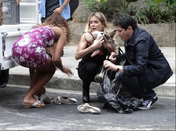 Natalie tenta recuperar os sapatos espalhados pela rua.(Imagem:Insensato Coração / TV Globo)