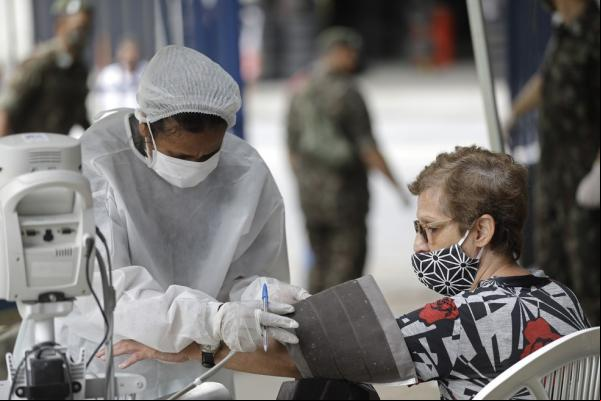Uma profissional de saúde mede a pressão arterial de uma mulher com suspeita de Covid-19 na Unidade de Pronto Atendimento (UPA) Marechal Hermes, no Rio de Janeiro, em 6 de maio.(Imagem:Silvia Izquierdo/AP/Arquivo)